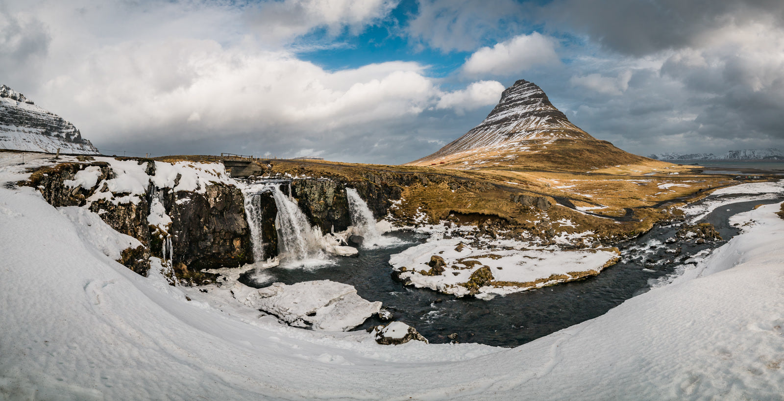 Snow-covered Kirkjufell mountain and waterfalls in Iceland
