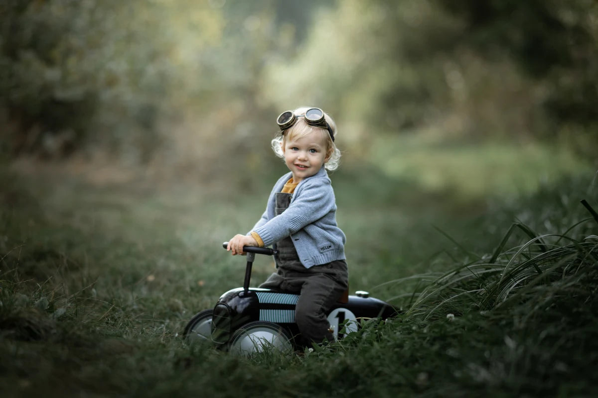 A finished action portrait of a child riding through a forest
